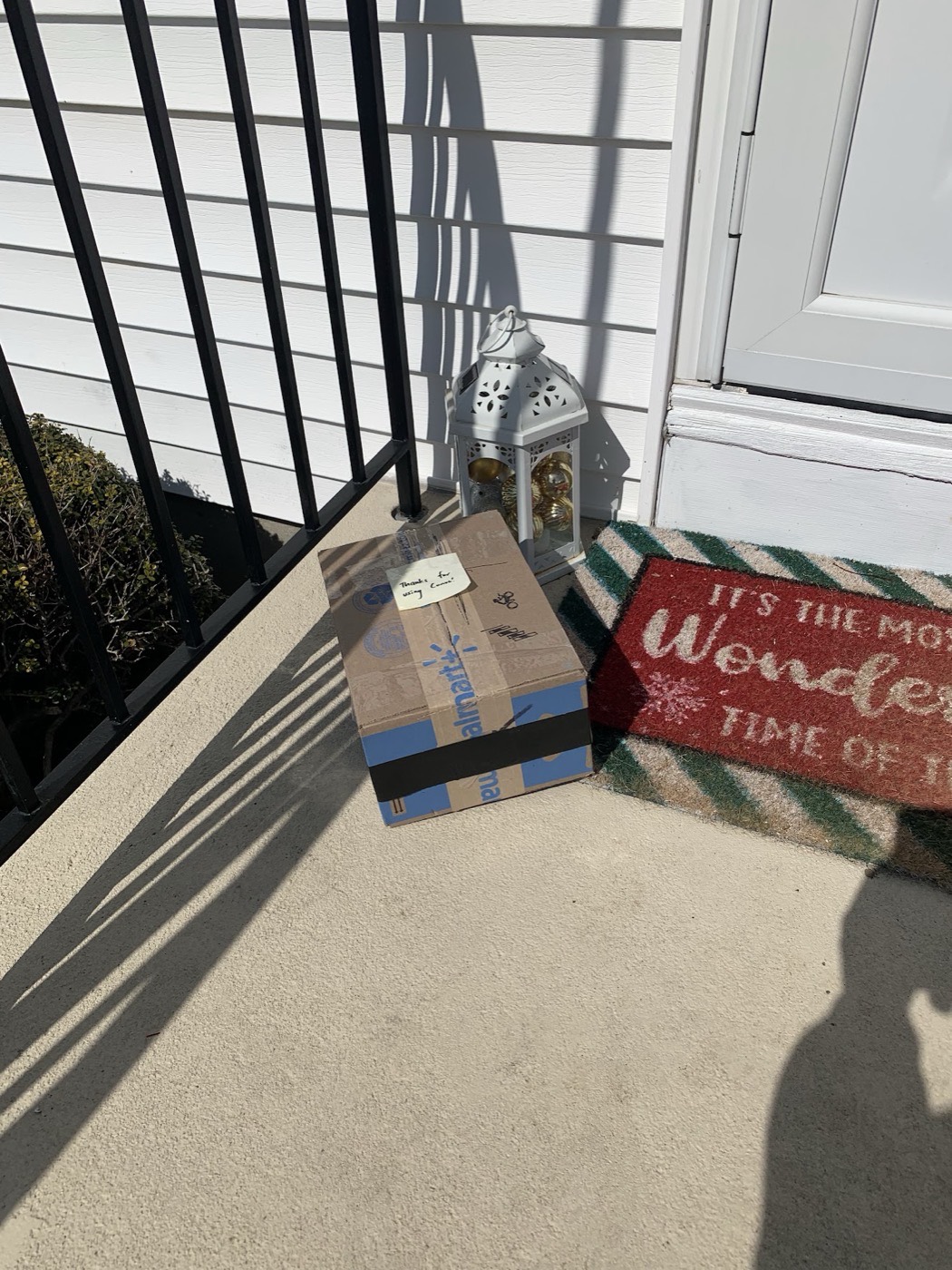 A cardboard box on a porch doormat with a handwritten note taped to it reading “Thanks for using Convo!”